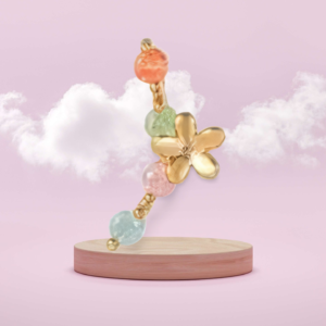 Gold floral earring with colorful pastel beads and a delicate flower design, set against a pink background with clouds